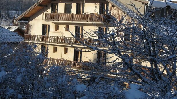 A multi-story building with balconies, surrounded by snow-covered trees. - Cozy Studio with Wi-Fi, BBQ, Summer Pool, Near Ski Pistes & Free Village Shuttle (Saint-Chaffrey)