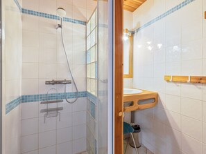 Un baño con ducha, lavabo y espejo.