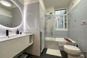 A modern bathroom with a shower, toilet, and sink.