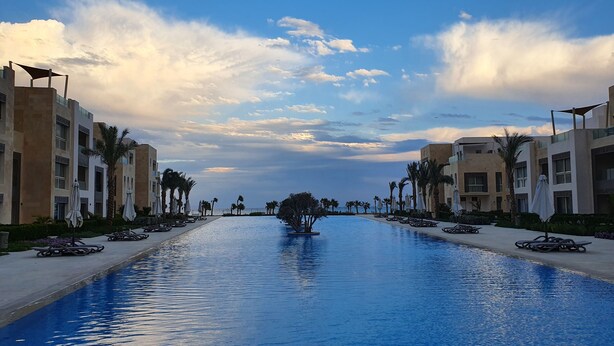 A swimming pool flanked by modern buildings with palm trees and sun loungers. - El Gouna - Sea view - Kitesurfing  (Hurghada)