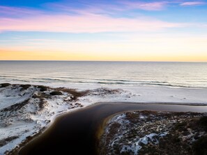 Enjoy the serene coastal landscape with a gentle beach curve leading into the ocean.