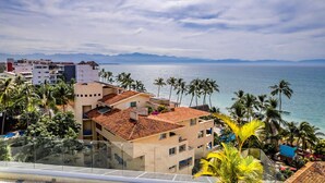 A coastal view with buildings, palm trees, and a clear sky. - Casa Kaia, Ocean-View Boho-Chic, 2bd/2ba Condo in Golden Zone (Bucerías)