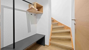 A modern staircase with wooden steps and a black metal handrail. - Hotel Garni Traube (Friedrichshafen)