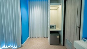 Una stanza con una parete blu, un pavimento in legno, un armadio e una piccola credenza.