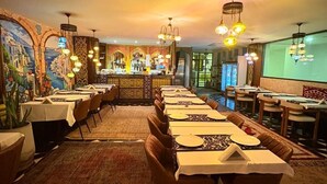 Un ristorante con diversi tavoli, un'area bar e un murale sulla parete.