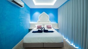 Una camera d'albergo moderna con un letto grande, un pannello decorativo e un lucernario.