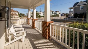 A covered porch with white railings, a brick column, and a white bench. - Convenient | 2 King Beds l Fast Wifi (Norfolk)