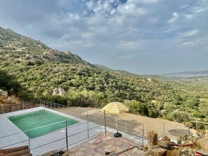 Un espace piscine offrant une vue sur un paysage montagneux.