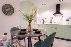 Enjoy meals in this stylish dining area with a round table for four, featuring a beautiful centerpiece and comfortable seating.