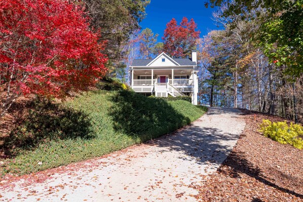 A house with a porch, surrounded by trees with autumn foliage. - Willkommen Haus - Perfect Gathering Place for Friends and Family (Helen)