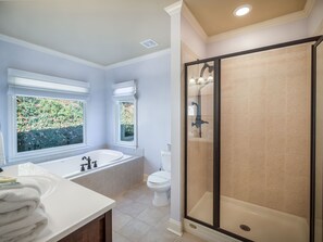 A modern bathroom with a bathtub, toilet, and shower.
