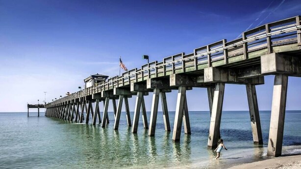 A pier extending into calm waters with a clear sky. - Tropical house and pool - 1/2 mile away from beach (South Venice)