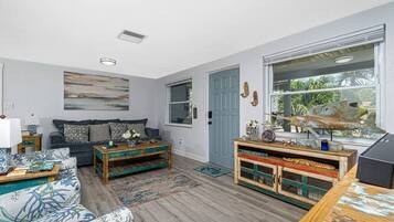 Ein Wohnzimmer mit einer Couch, einem Couchtisch und einer Holzkabine mit Dekoration.