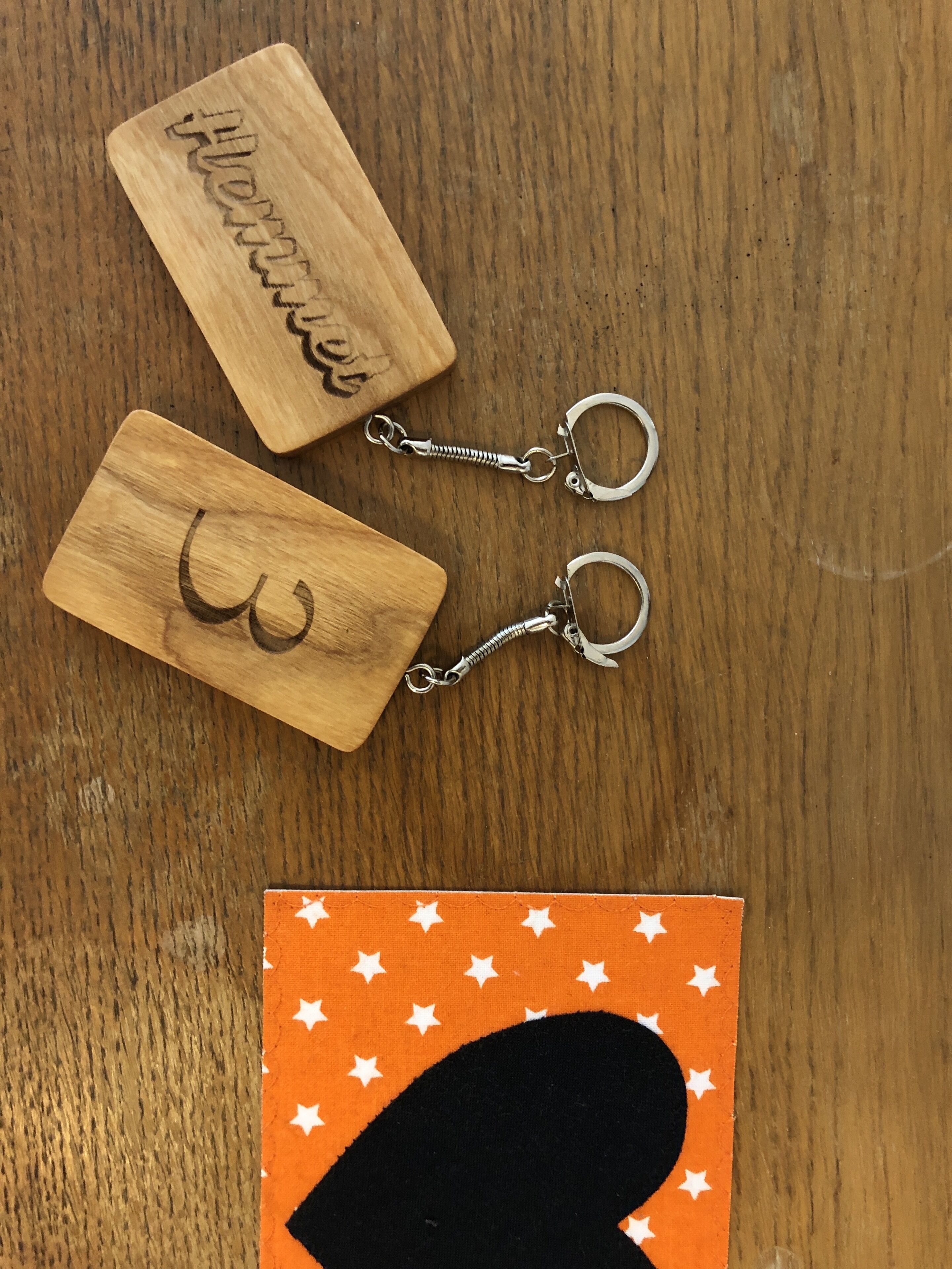 Houten sleutelhangers met gegraveerde tekst en een kaartje met een stermotief.