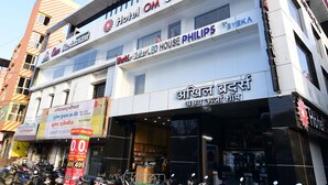 Un immeuble à plusieurs étages, avec des enseignes indiquant la présence d’un hôtel, d’un restaurant et d’un magasin Philips.