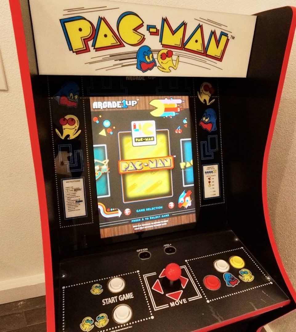 Une borne d’arcade Pac-Man dotée d’un écran de sélection de jeux et de boutons de contrôle.