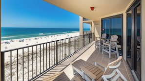A balcony with a view of the beach and ocean.