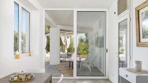 A modern interior with a sliding glass door leading to an outdoor patio area. - Trullo Chiara con piscina by Wonderful Italy (Ostuni)