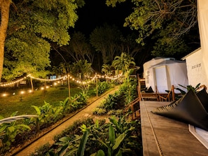 A garden pathway leading to a white tent-like structure, surrounded by lush greenery and string lights. - Vanara Bungalows & Restaurant (Ko Chang)