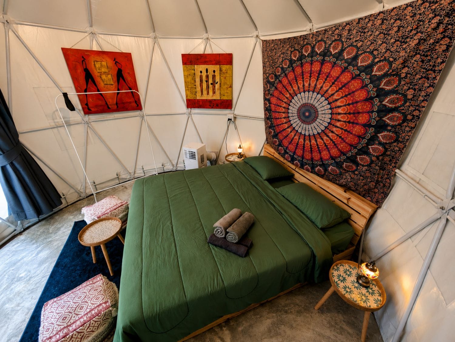 Una camera a tenda con un letto, un arazzo e opere d'arte alle pareti.