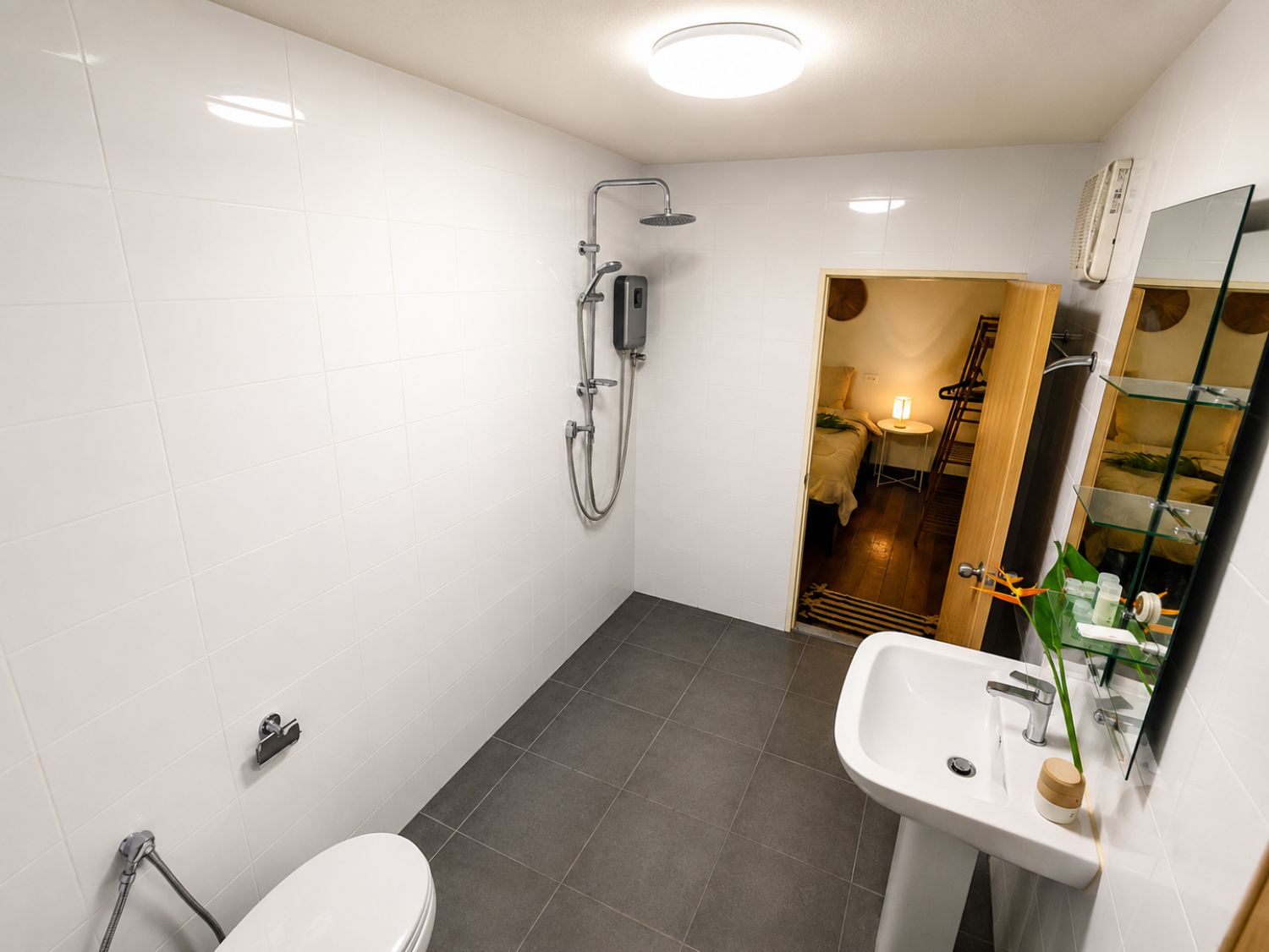 A modern bathroom with a shower, toilet, and sink.