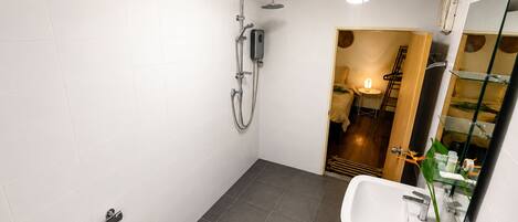 A modern bathroom with a shower, toilet, and sink.