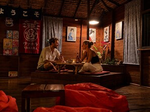 A traditional wooden interior with tatami mats, a low table, and cultural decorations.