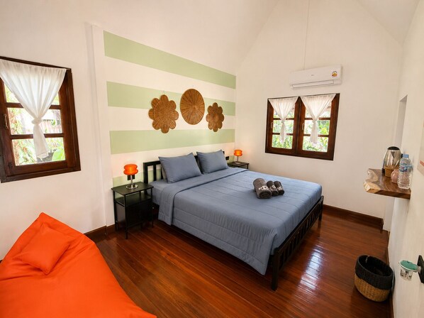 A bedroom with a bed, nightstands, a chair, and decorative wall art.