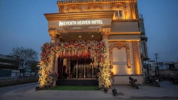 The exterior of the Seventh Heaven Hotel with a prominent entrance, a sign above the entrance, and a decorative archway.