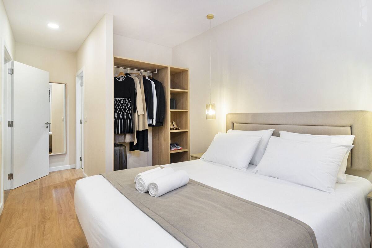 Une chambre d’hôtel avec un grand lit, une armoire et un dressing.