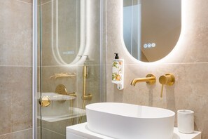 Standaard appartement | Badkamer | Een douche, een regendouche, een haardroger, handdoeken