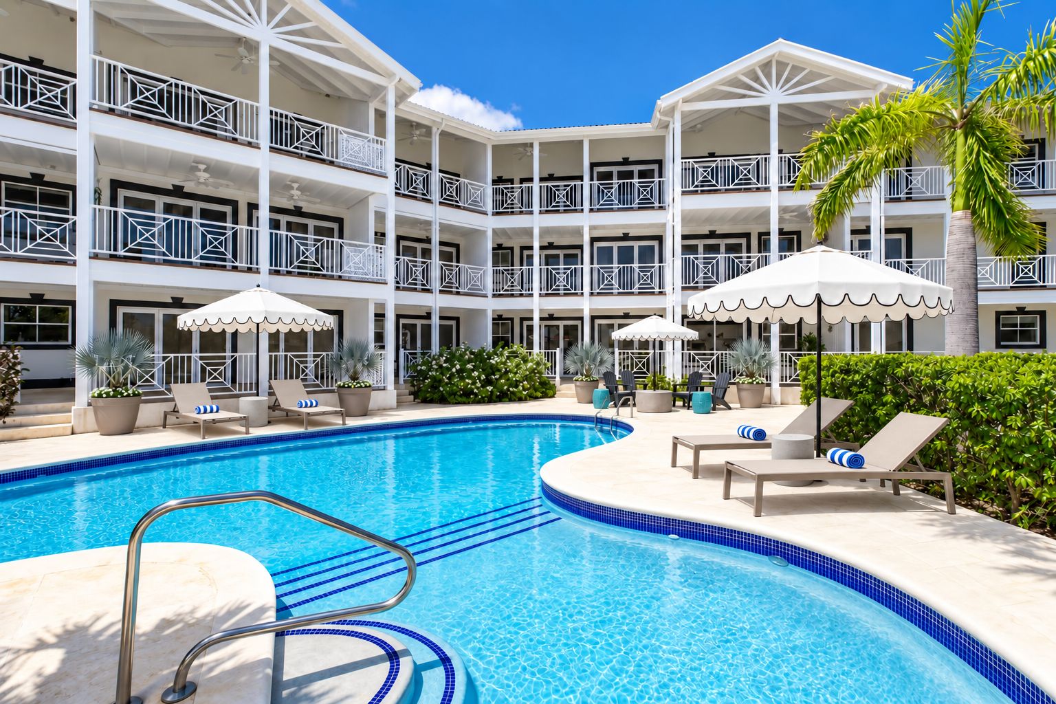 Un hotel con zona de piscina, varios balcones y mobiliario exterior con sombrillas.