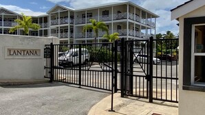 Un hôtel à plusieurs étages, doté de balcons et d’une entrée sécurisée par un portail.