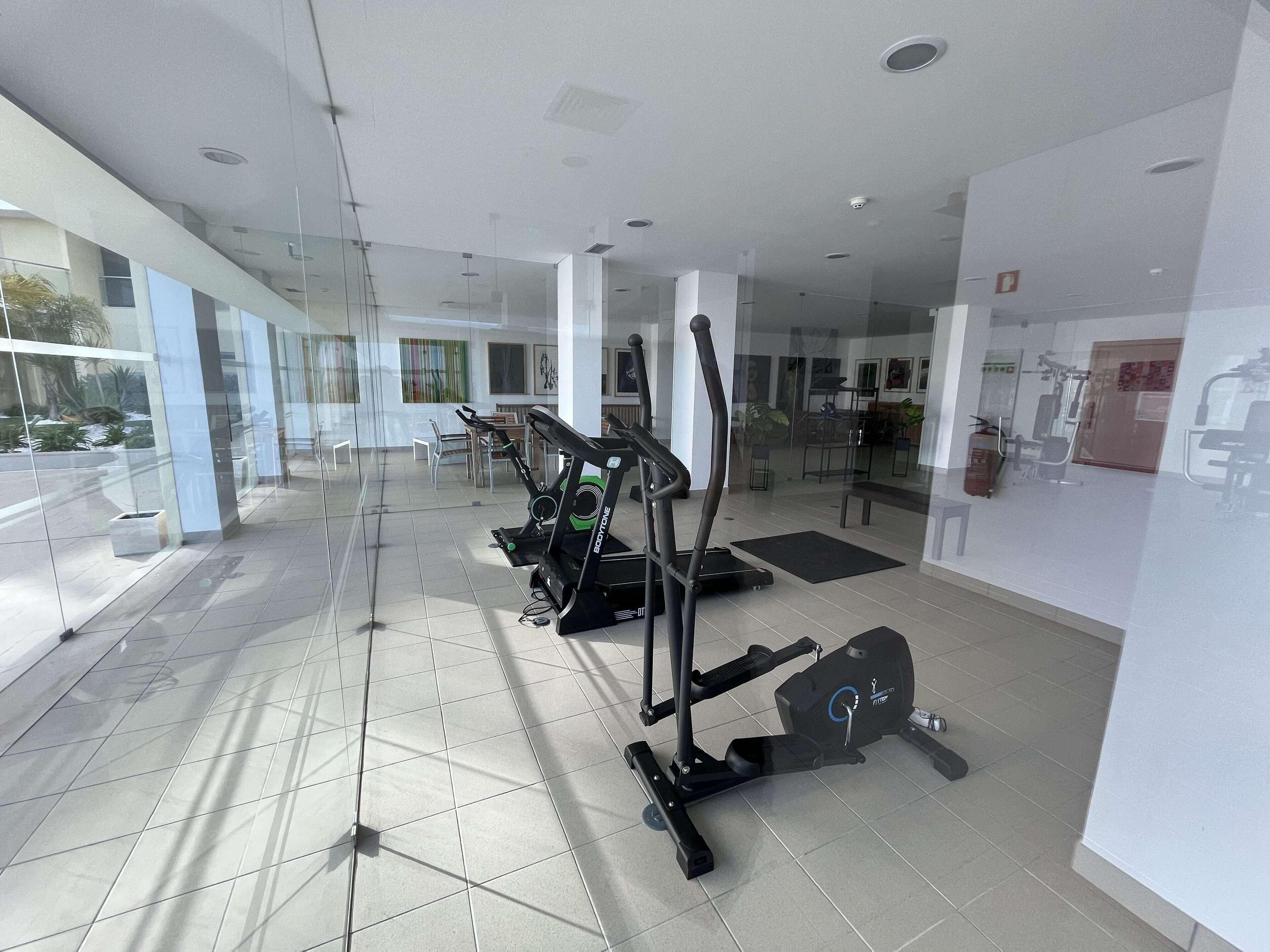 A modern gym with cardio machines and a clean, spacious layout.