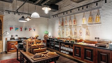 Un bufé de desayuno con diversos alimentos, muebles de madera y bolsas colgantes con letras.