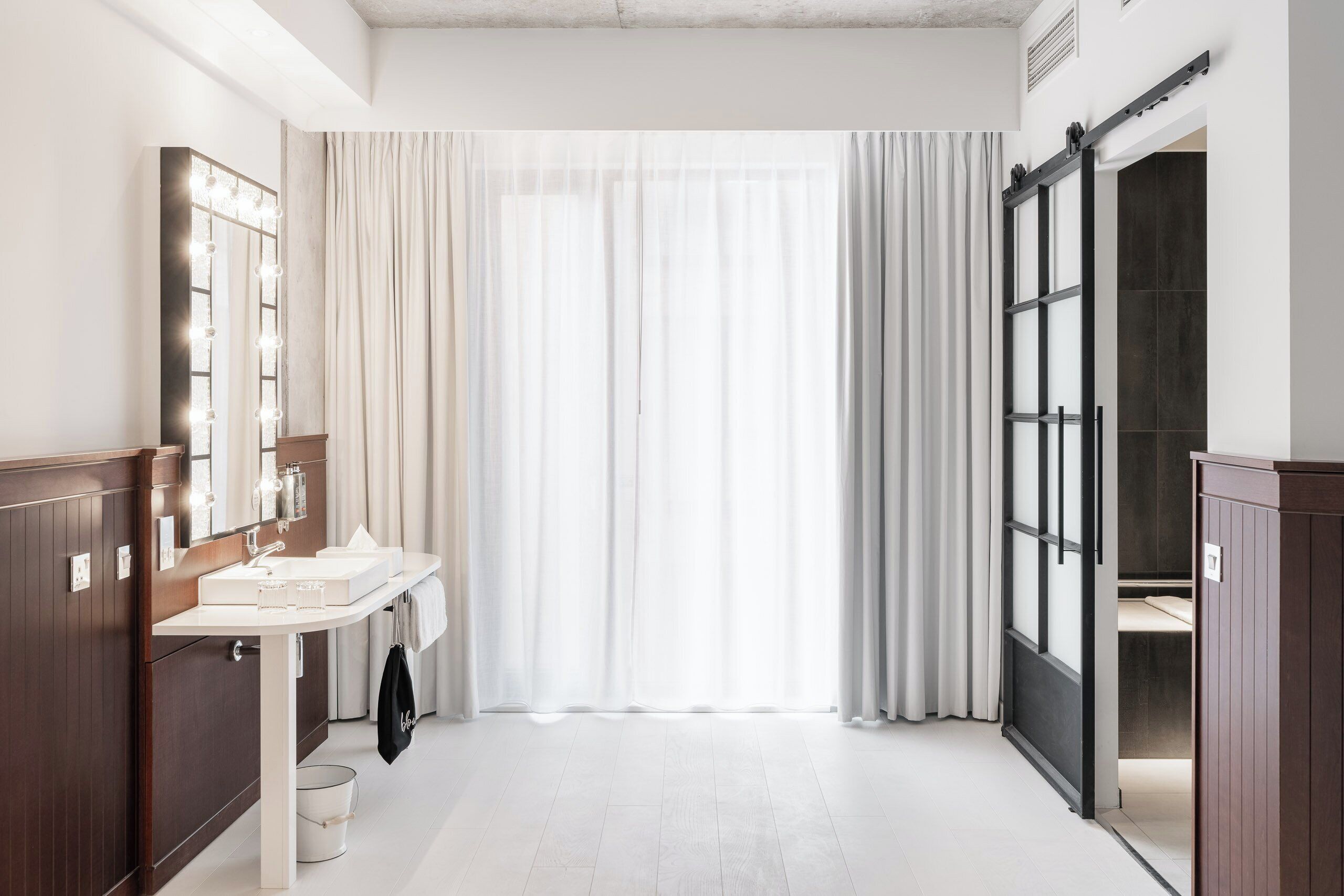 A modern bathroom with a vanity, mirror, and sliding door.