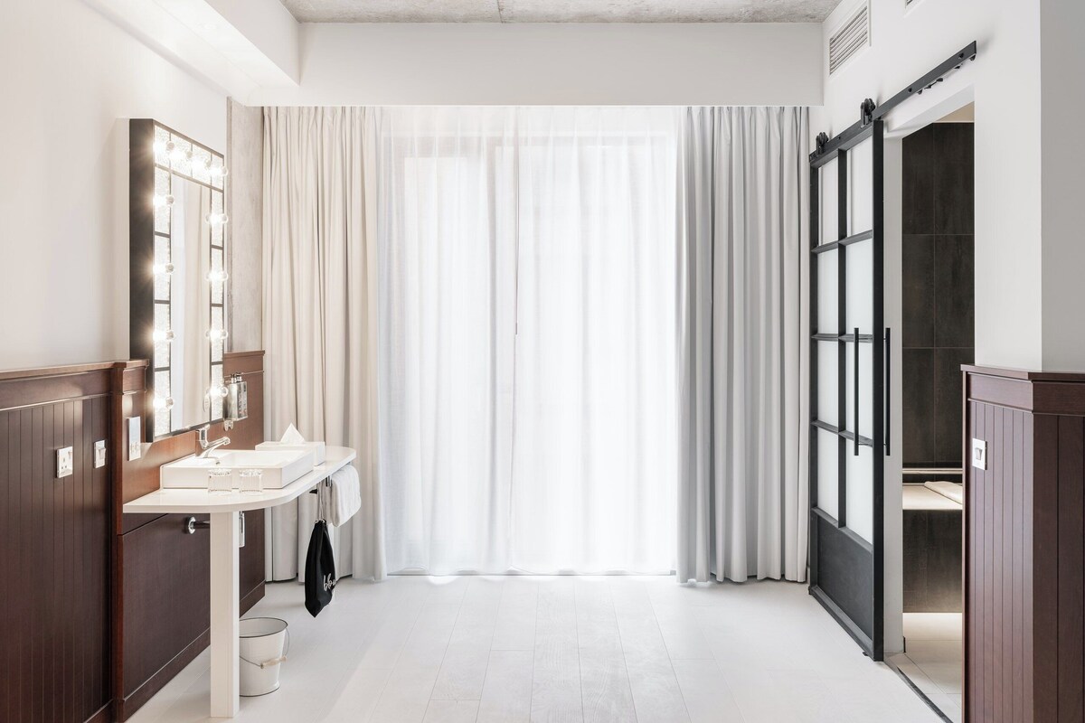 A modern bathroom with a vanity, mirror, and sliding door.