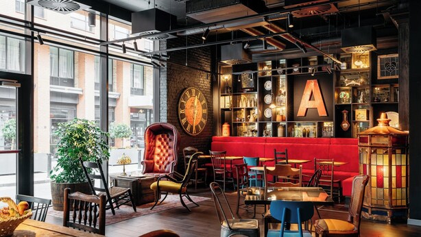 A modern interior with a large 'A' on the wall, a red booth, and a variety of seating arrangements. - Ruby Molly Hotel Dublin by IHG (Dublin)