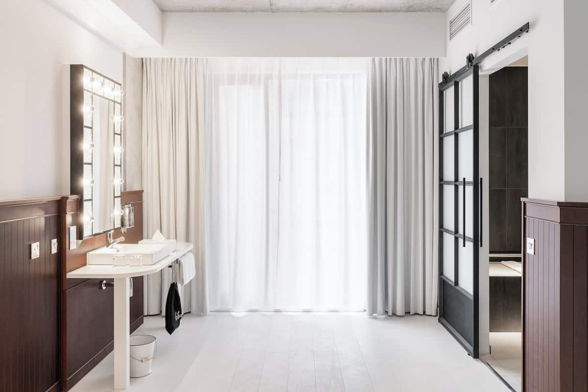 A modern bathroom with a vanity, mirror, and sliding door.