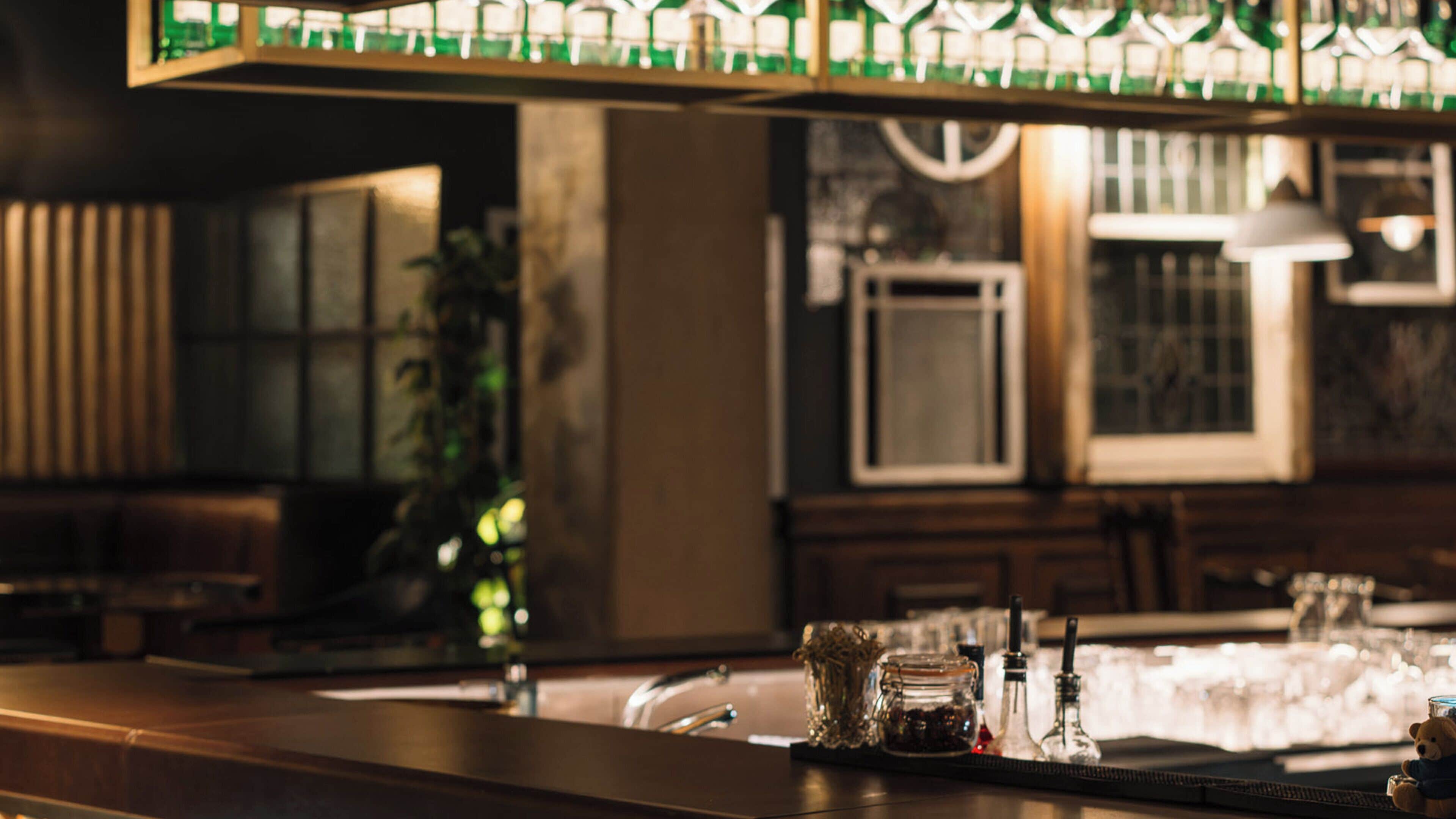 Eine Bar mit Theke, Barhocker, einer Pendelleuchte und einem Fenster mit Blick.