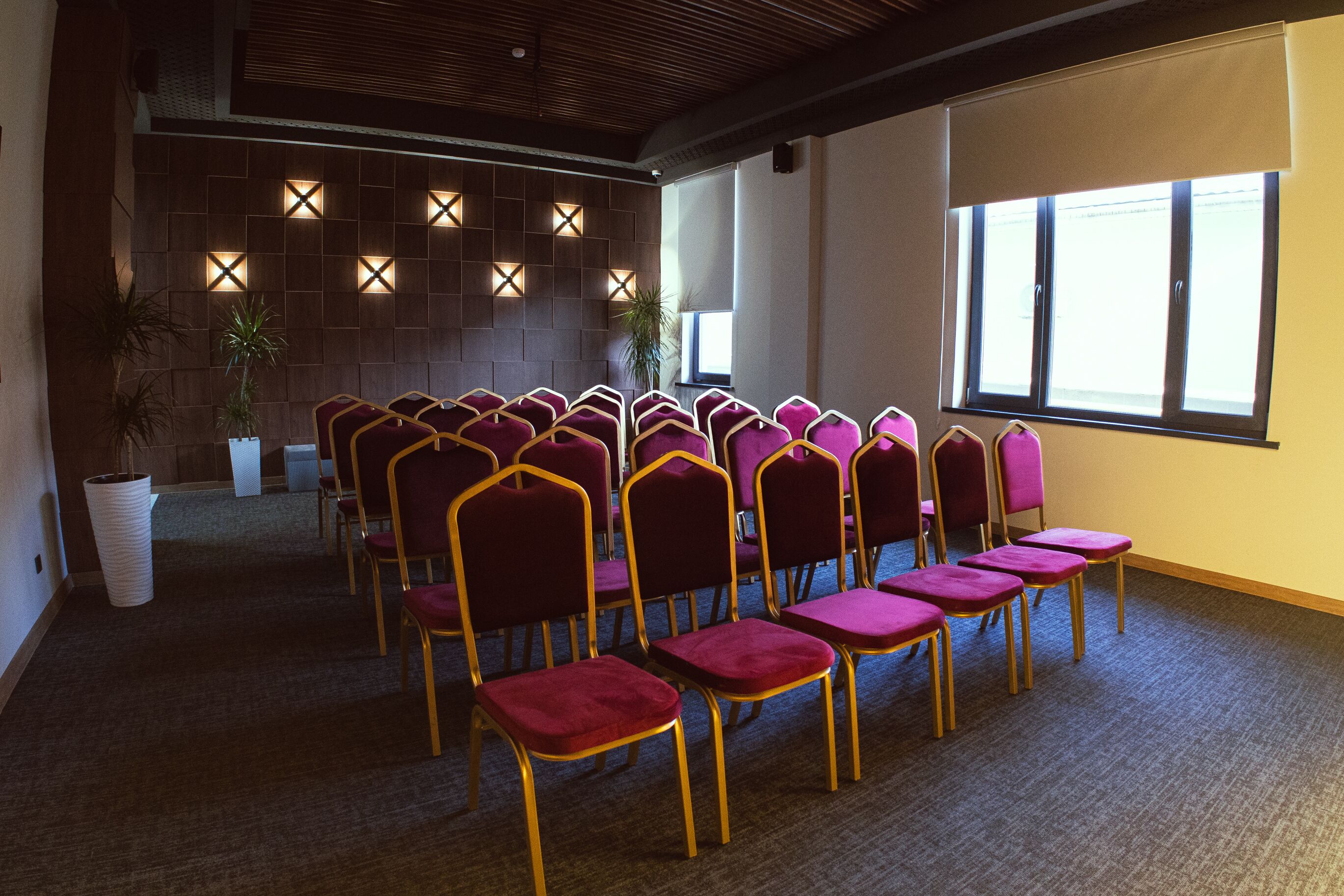 A conference room with rows of purple chairs and a large window.