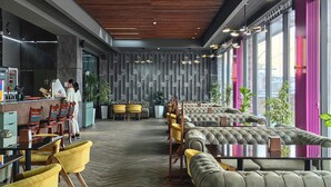 A modern interior with a wooden ceiling, seating areas, and a reception desk. - Shymkent Park Hotel (Shymkent)