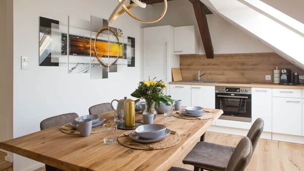 A modern kitchen with white cabinets, a wooden countertop, and a built-in oven. - Modernes Apartment im Zentrum der Stadt (Graz)