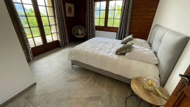 Ein Schlafzimmer mit einem Bett, einem Sessel und einem kleinen Tisch.