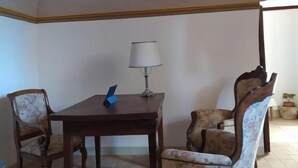 A dining area with a table and chairs, a lamp, and a decorative ceiling. - Locanda di Posta (L'Aquila)