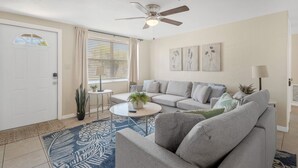 A living room with a sofa, coffee table, and a ceiling fan.