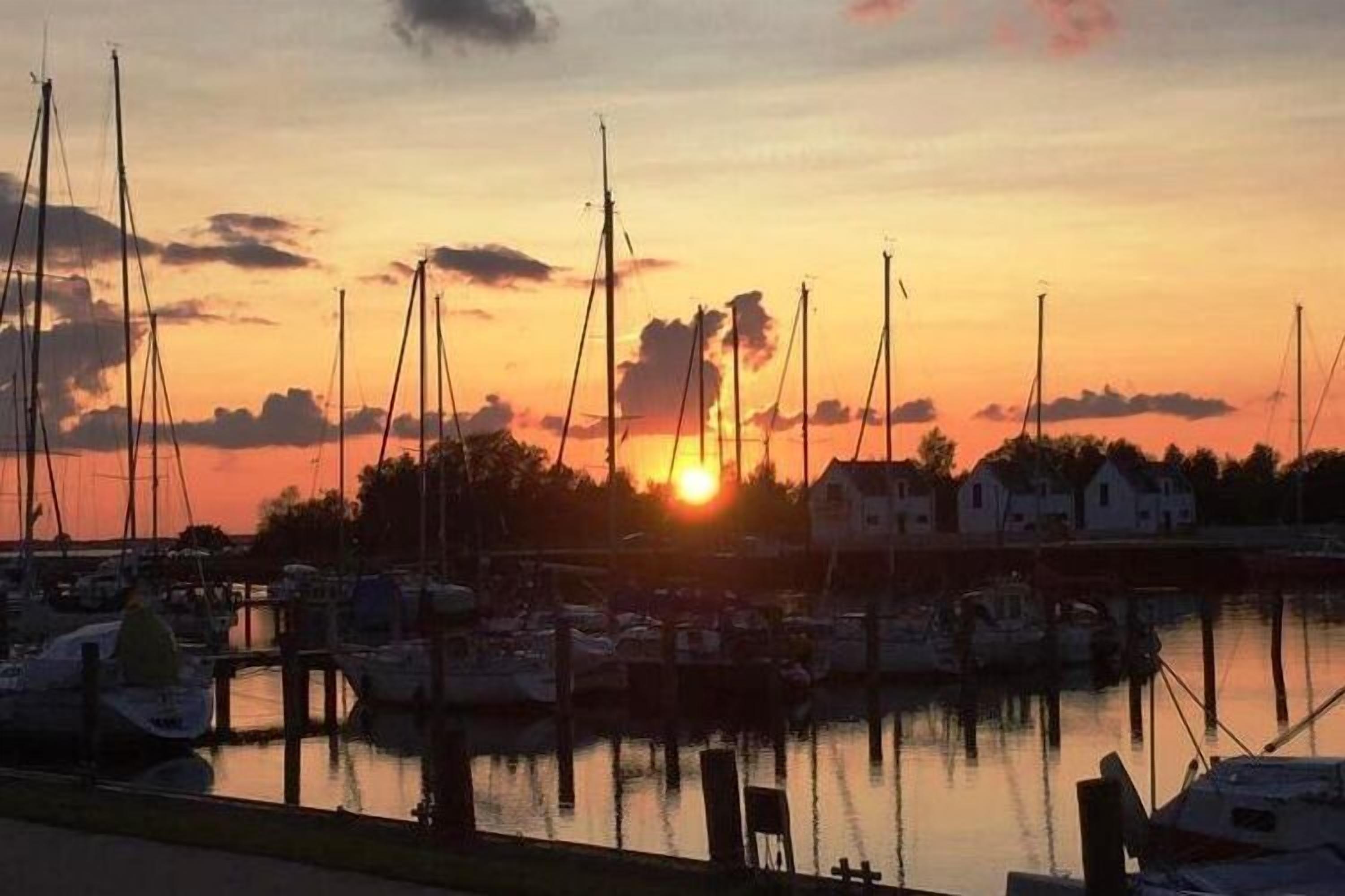 Un port de plaisance avec des bateaux amarrés au coucher du soleil.