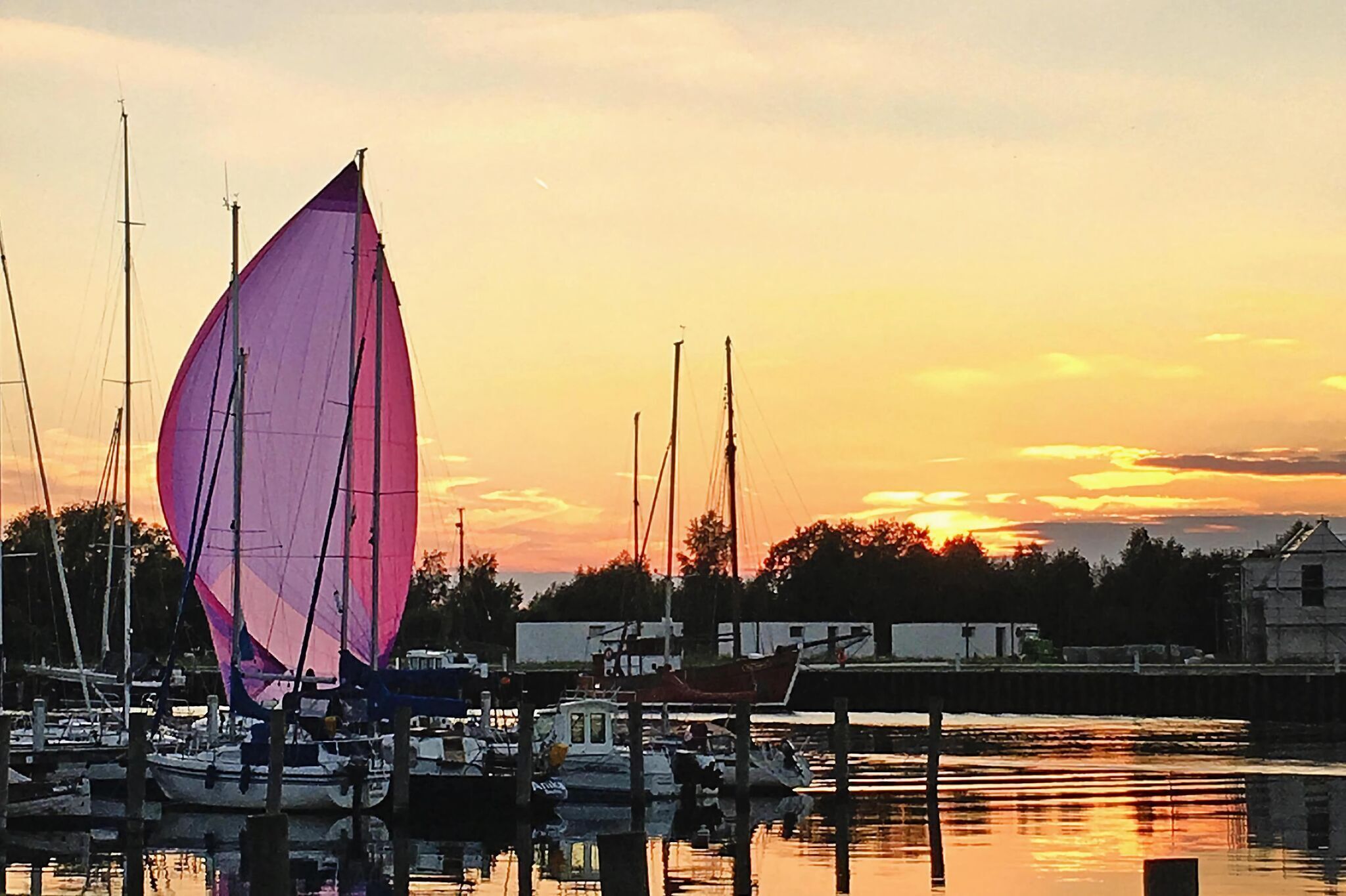 A marina with boats docked at sunset.