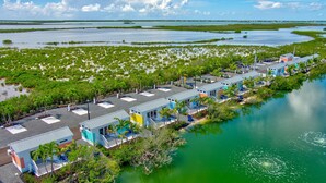 A coastal hotel with multiple colorful buildings along a waterfront, surrounded by mangrove areas. - Pet-Friendly Lakefront Bunglaow - Sugarloaf Key - Great Amenities (21) (Summerland Key)