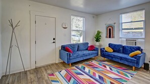 A living room with two blue sofas, a colorful rug, and a white door. - NorthEnd Stylish Home Near Hiking Trails & BSU (Boise)